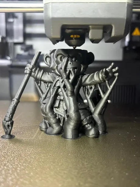 Sun Wukong-beeldje half geprint op het bed van de Bambu Lab P2S, met de printkop erboven